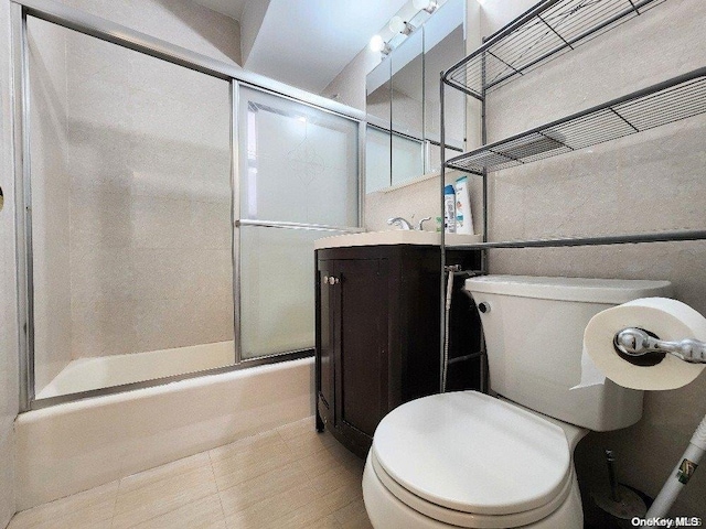 full bathroom featuring vanity, enclosed tub / shower combo, and toilet