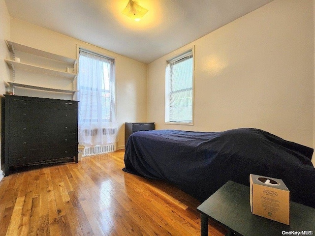 bedroom featuring vaulted ceiling and light hardwood / wood-style flooring