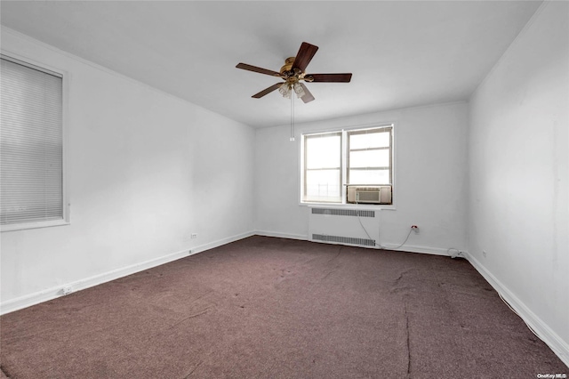 unfurnished room featuring radiator, cooling unit, baseboards, ceiling fan, and dark carpet