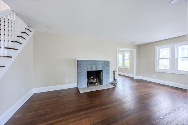 unfurnished living room with a fireplace and dark wood-type flooring