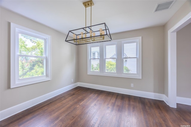 unfurnished dining area featuring a notable chandelier and dark wood-type flooring