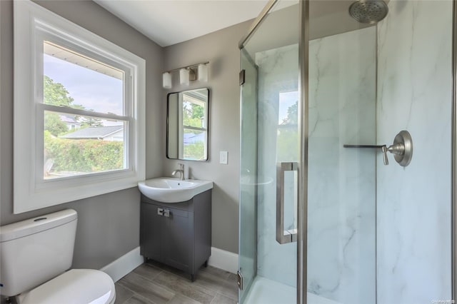 bathroom with wood-type flooring, vanity, toilet, and a shower with door