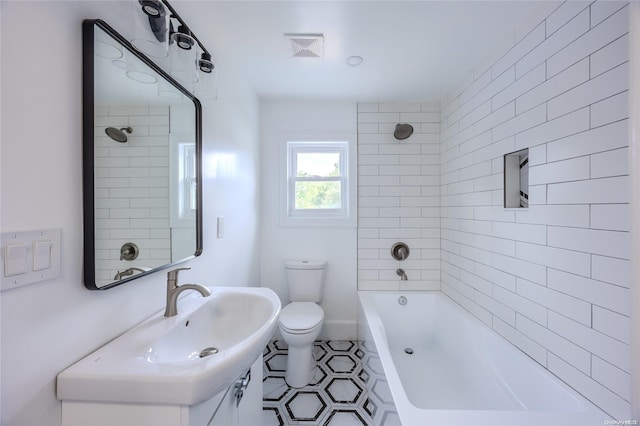 full bathroom featuring sink, tile patterned flooring, tiled shower / bath combo, and toilet