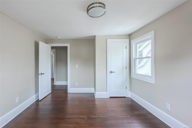 unfurnished bedroom with a closet and dark hardwood / wood-style flooring