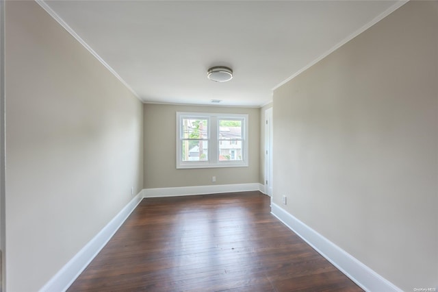 empty room with ornamental molding and dark wood-type flooring