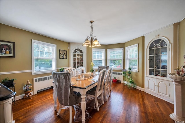 dining area with dark hardwood / wood-style floors, an inviting chandelier, and radiator