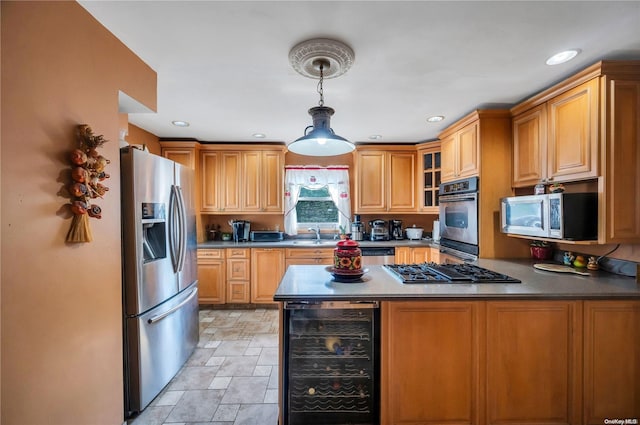 kitchen featuring pendant lighting, beverage cooler, stainless steel appliances, and sink