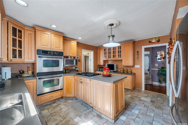 kitchen with pendant lighting, light brown cabinets, appliances with stainless steel finishes, and sink