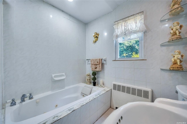 bathroom featuring tile walls, radiator, and tiled bath