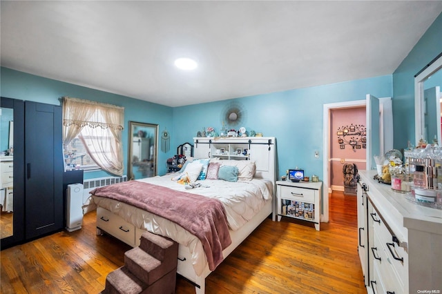 bedroom with hardwood / wood-style floors and radiator