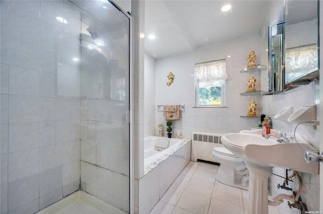 bathroom with separate shower and tub, radiator, tile walls, and toilet