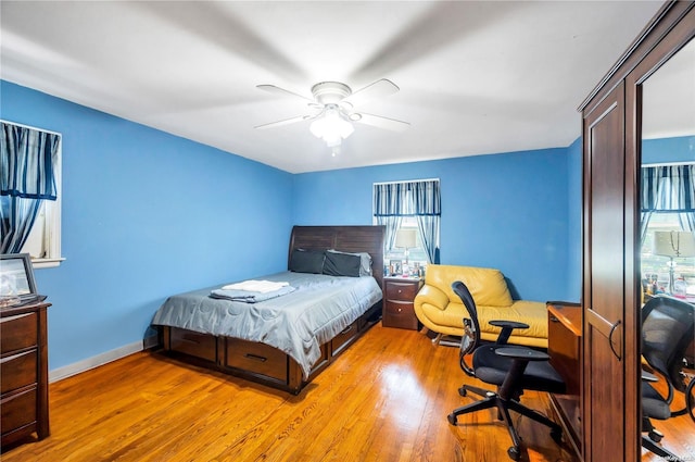 bedroom featuring light hardwood / wood-style floors, multiple windows, and ceiling fan