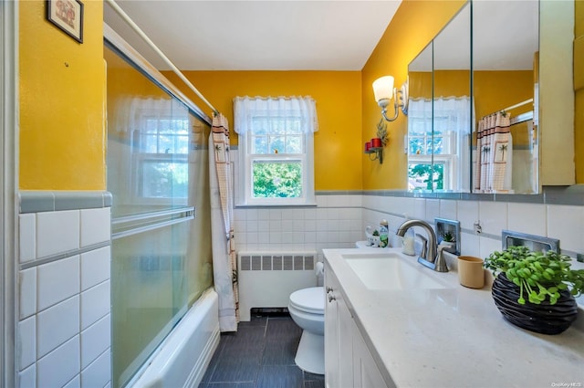 full bathroom featuring shower / bath combination with curtain, radiator, vanity, tile walls, and toilet