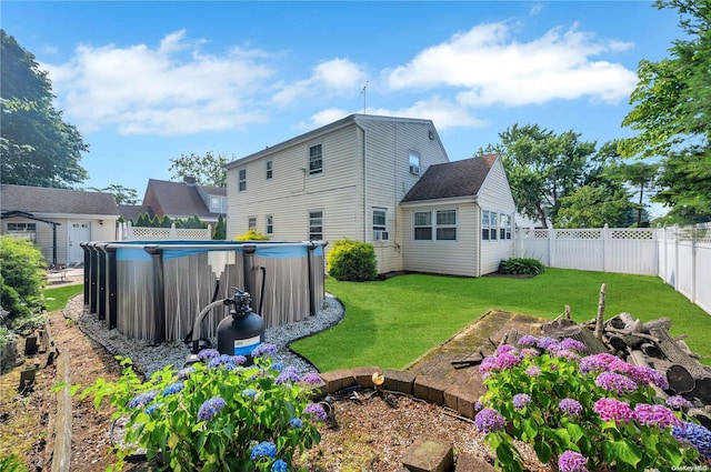 back of property with a fenced in pool and a lawn