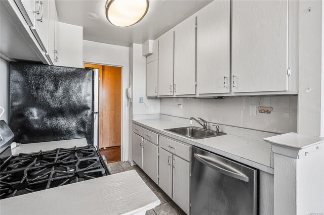 kitchen with gas stove, sink, stainless steel dishwasher, refrigerator, and white cabinets