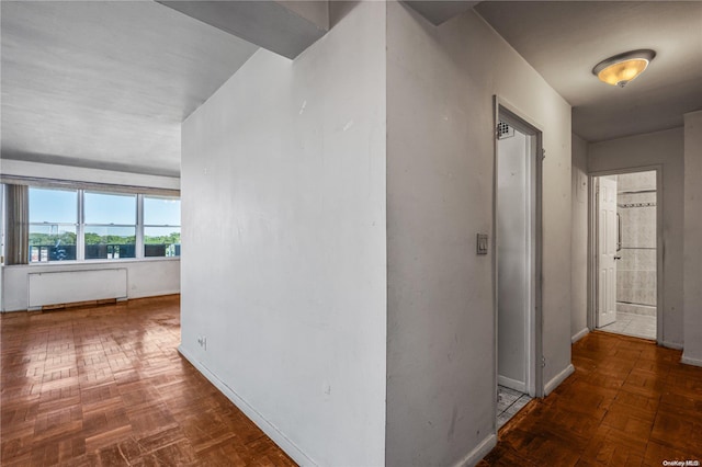 corridor with radiator heating unit and dark parquet floors