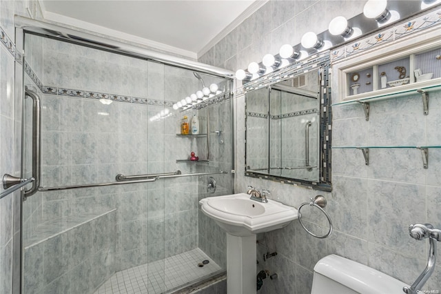 bathroom with a tile shower, toilet, tile walls, and sink