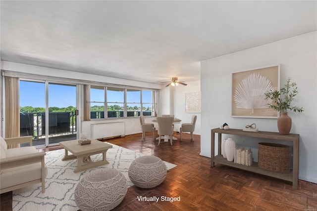 living room featuring radiator heating unit, dark parquet floors, and ceiling fan