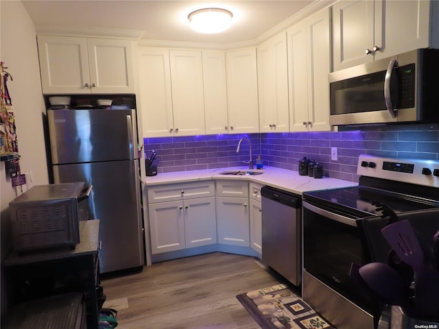 kitchen featuring white cabinets, sink, stainless steel appliances, and light hardwood / wood-style flooring