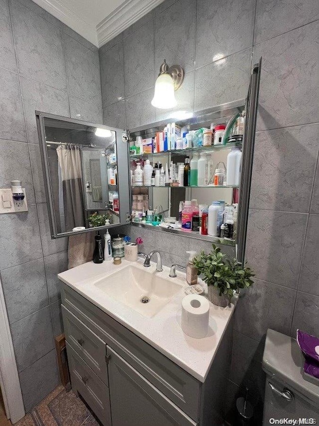 bathroom featuring vanity, crown molding, tile walls, toilet, and curtained shower