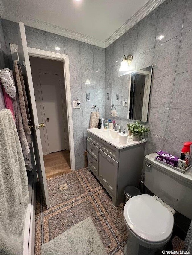 bathroom with vanity, toilet, crown molding, and tile walls