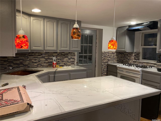 kitchen with exhaust hood, decorative backsplash, hanging light fixtures, and white gas range oven