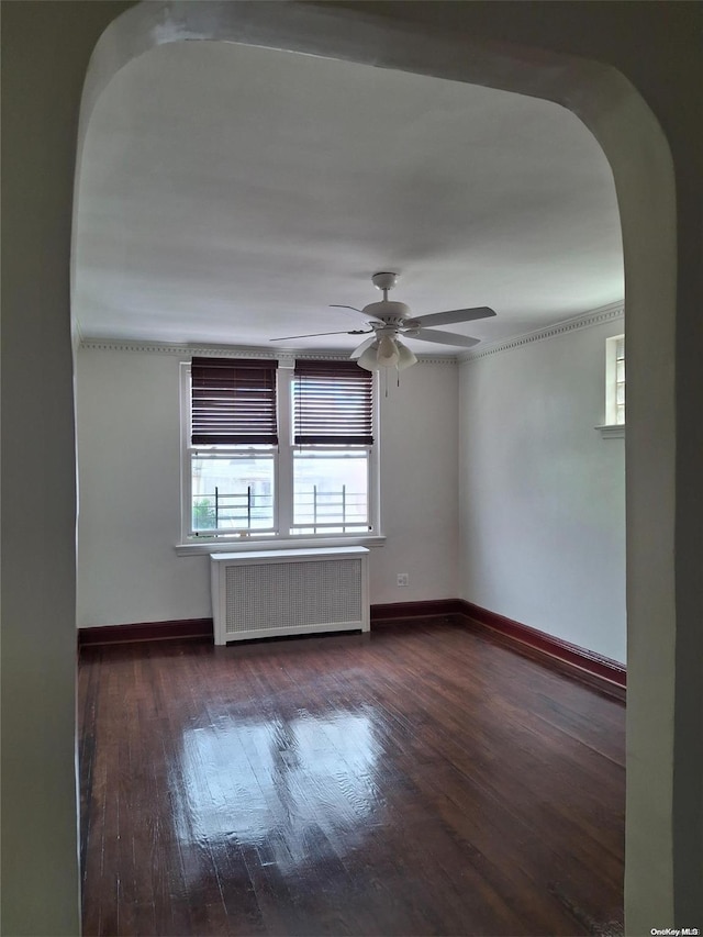 spare room with radiator, ceiling fan, and dark hardwood / wood-style flooring