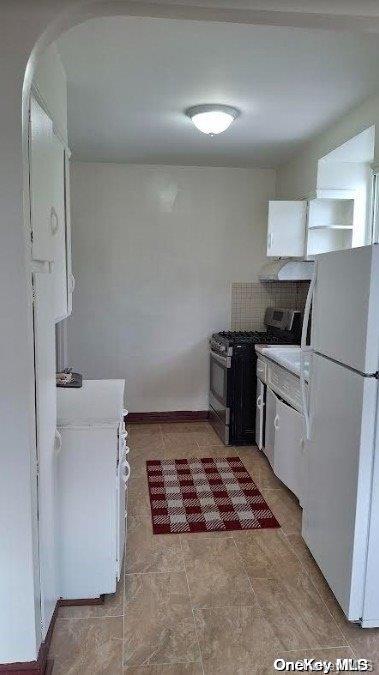 kitchen with stainless steel range with electric stovetop, white fridge, and white cabinetry