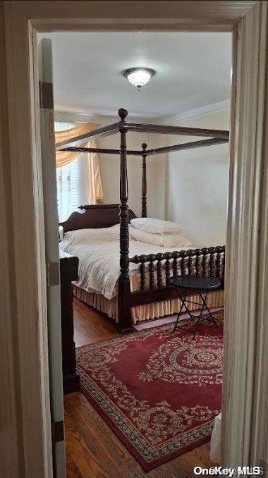 bedroom featuring hardwood / wood-style floors and ornamental molding