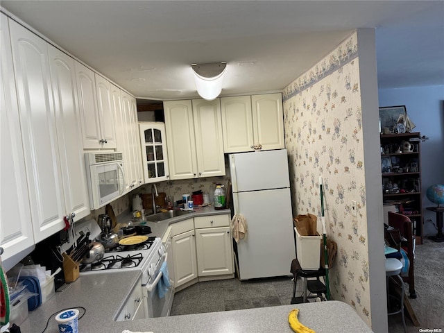 17-85 215th St Unit 4J, Bayside, NY 11360 - kitchen with white appliances, a sink, glass insert cabinets, wallpapered walls, and white cabinets