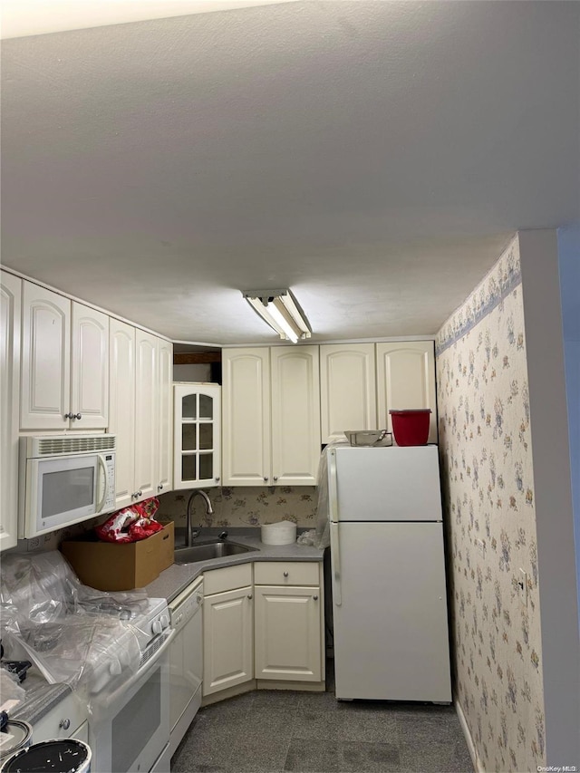 kitchen featuring white cabinets, white appliances, and sink