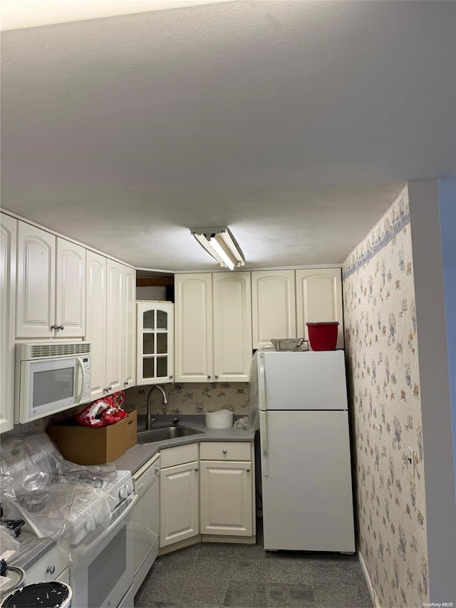 17-85 215th St Unit 4J, Bayside, NY 11360 - kitchen with white appliances, wallpapered walls, a sink, and white cabinets