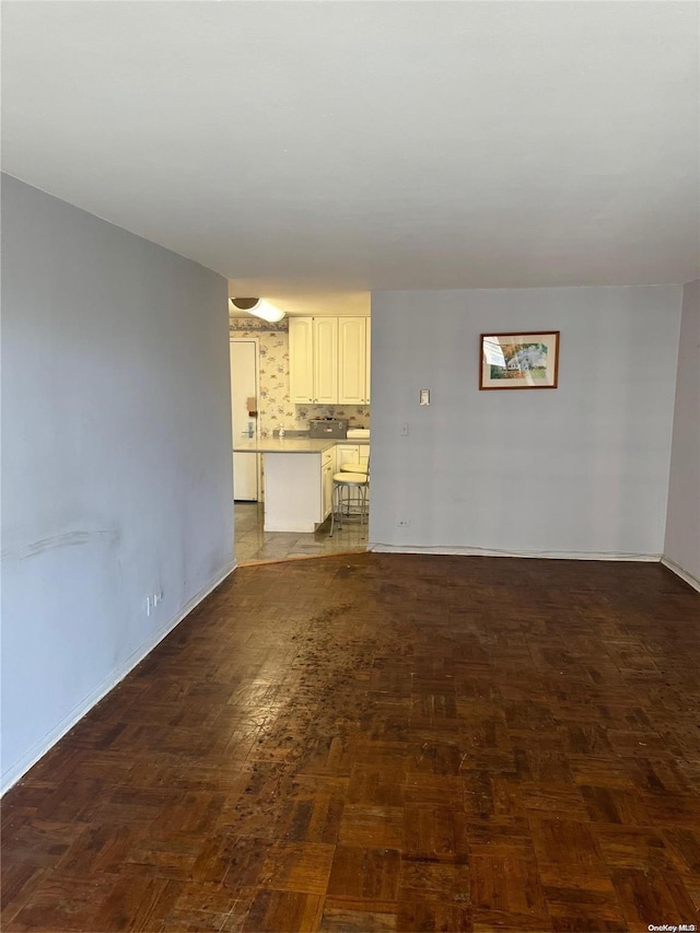 unfurnished living room with dark parquet flooring