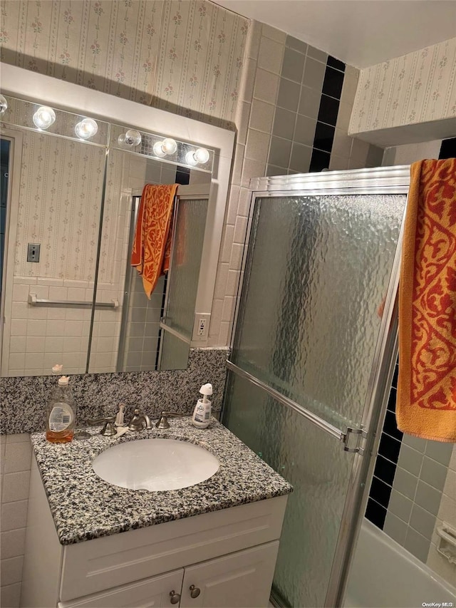 17-85 215th St Unit 4J, Bayside, NY 11360 - bathroom with vanity, a shower with door, wallpapered walls, and tile walls
