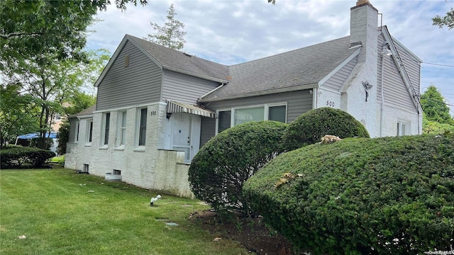 view of side of home with a yard