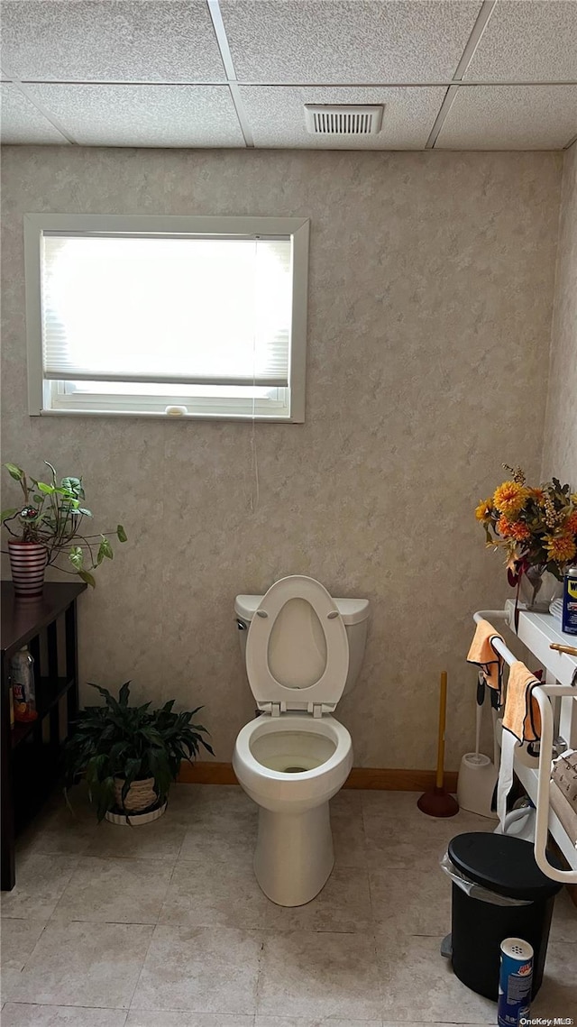 bathroom with a paneled ceiling and toilet