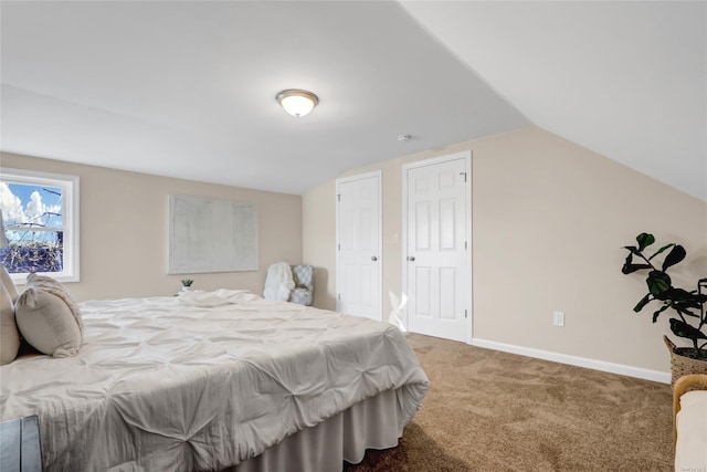 carpeted bedroom with lofted ceiling