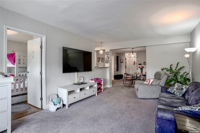 living room with light carpet and an inviting chandelier