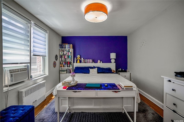 bedroom with radiator heating unit, dark hardwood / wood-style flooring, and cooling unit