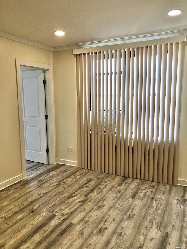 empty room featuring a wealth of natural light, crown molding, and hardwood / wood-style flooring