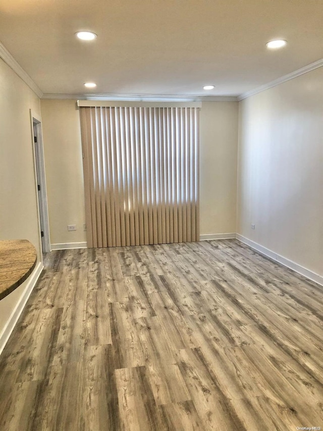 empty room with hardwood / wood-style floors and ornamental molding