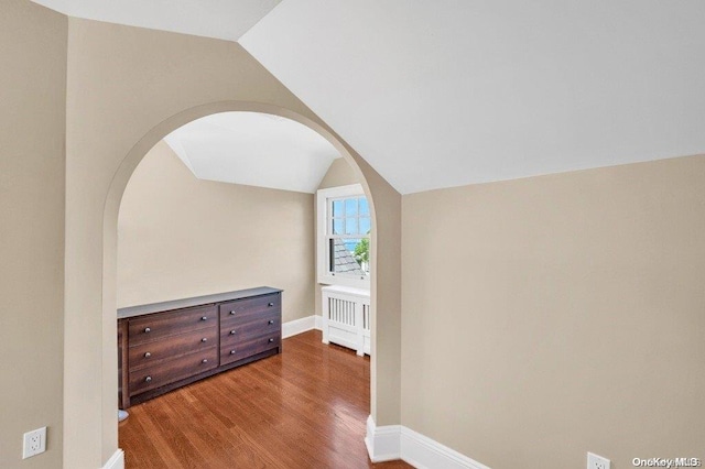 262 Howard Ave, Staten Island, NY 10301 - hall featuring arched walkways, vaulted ceiling, wood finished floors, baseboards, and radiator heating unit