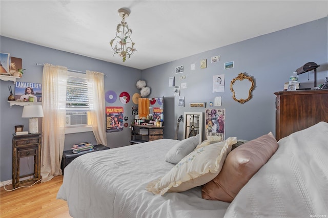 bedroom with cooling unit and light hardwood / wood-style flooring