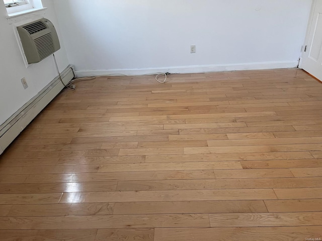 room details with wood-type flooring, an AC wall unit, and a baseboard heating unit