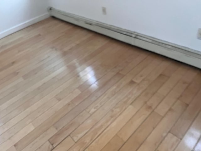 interior details featuring wood-type flooring and a baseboard heating unit