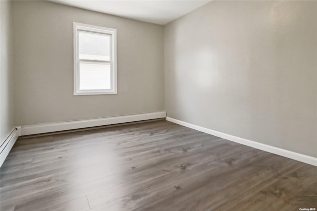 spare room with wood-type flooring and a baseboard radiator