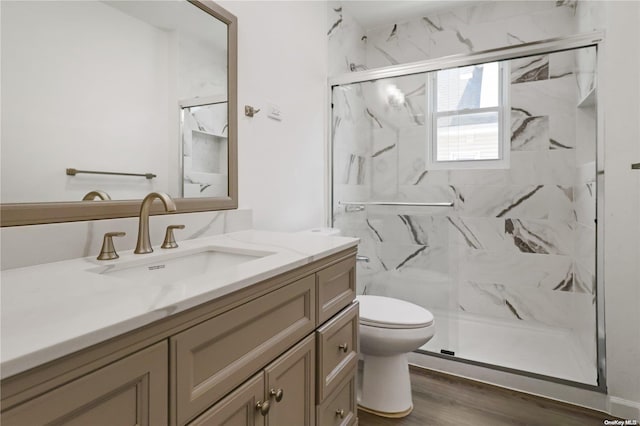 bathroom featuring toilet, hardwood / wood-style floors, vanity, and walk in shower