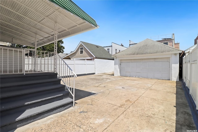 exterior space with a garage and an outbuilding