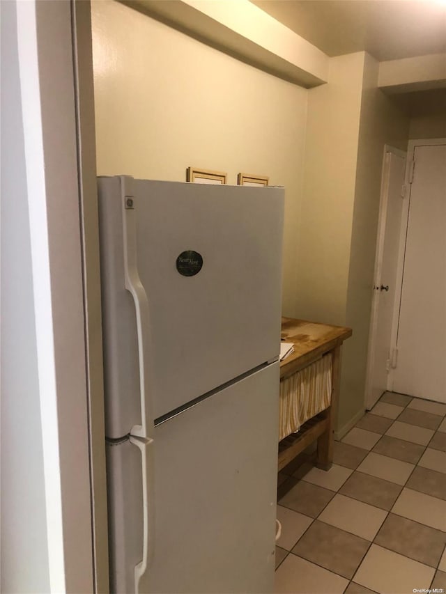 kitchen with white refrigerator and light tile patterned flooring