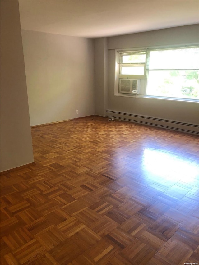 spare room featuring dark parquet floors and baseboard heating